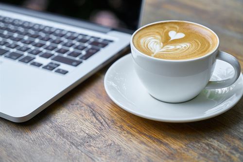 laptop next to a cup of coffee