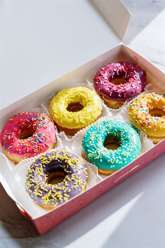 open box of 6 multicolored sprinkle donuts